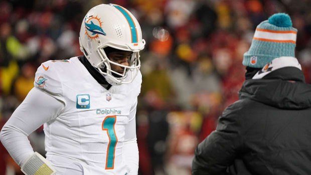 Tua Tagovailoa talks to Mike McDaniel on the sideline during a wild-card loss to the Chiefs in frigid temperatures.